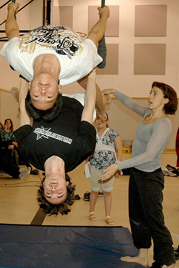 “I’ll try not to kick you,” laughs Nathaniel Palliser, on top, as he gets into the mirror position with the help of trainer Rebecca Leonard, right. (PHOTO BY SARAH ROGERS)