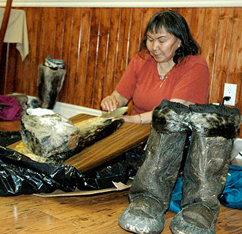 A Kangiqsujuaq woman shows a group of officials from Quebec’s tourism department how to clean a sealskin. (PHOTO BY SARAH ROGERS)