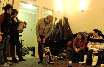 Nicole Ménard, Quebec’s minister for tourism, looks at a pair of kamiks during her March 23 visit to Kangiqsujuaq. (PHOTO BY SARAH ROGERS)