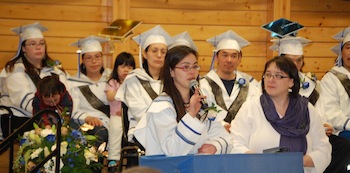 Student Cassandra Evaloakjuk takes the microphone, next to Fiona Buchan-Corey (right), Cambridge Bay’s Nunavut Arctic College campus director, at the graduation ceremony held April 15 at the Luke Novoligak community centre. (PHOTO BY KEVIN MCGILL)