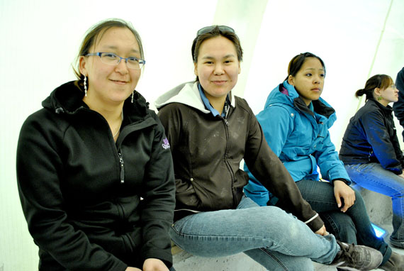 Daphne Quinangnaq and Cassandra Noah of Baker Lake, along with Sandy Kookeyuk of Arviat, all members of Meadowbank’s housekeeping staff, watch the June 18 ribbon-cutting ceremony as they await the start of their shift. (PHOTO BY JIM BELL)