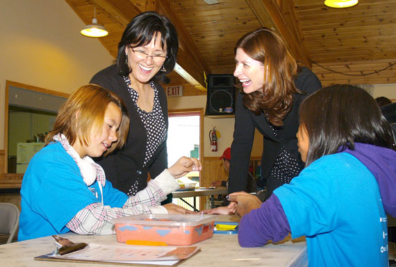 Leona Aglukkaq, the federal health minister and Nunavut's MP, and Jennifer Flanagan, the president and CEO of Actua science camps, watch kids at Iqaluit's parish hall do an activity July 14. Aglukkaq annouced $600,000 in federal funding over three years to support the Actua camps, which take place in nearly a dozen communities across Nunavut. (PHOTO BY CHRIS WINDEYER)