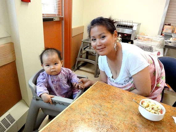 Cindy Tucktoo gives little Emma a snack in Larga Kitikmeot’s dining room. (PHOTO BY JANE GEORGE)