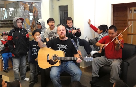 Musicians Greg Poapst and Ashlee Otokiak perform for an enthusiastic audience of kids held last month during a literacy week event. (PHOTO BY JANE GEORGE)