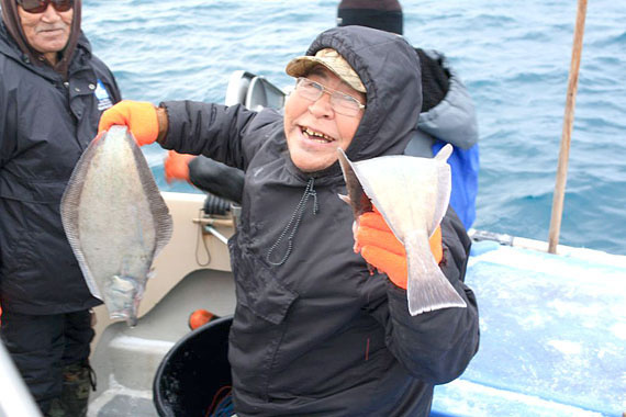 Philipoosee Kuniliusee of Pangnirtung displays two big turbot caught during an inshore fisheries project that he and four other Pangnirtung fisherman participated in during a trip to Ilulissat, Greenland this month. The Pangnirtung fishermen will spend four days observing the techniques, gear types and vessels that Greenlanders use in the Disko Bay inshore turbot fishery. (PHOTO COURTESY OF GN DEPARTMENT OF THE ENVIRONMENT)