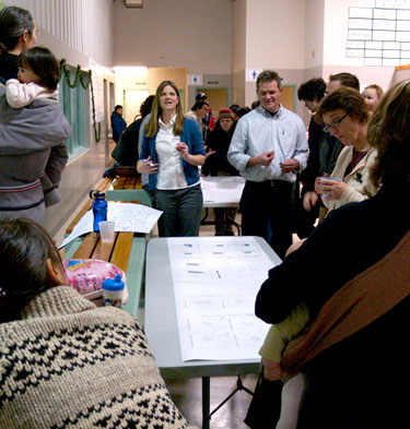 Iqalummiut gather round as Amy Elgersma, the City of Iqaluit's recreation director, explains elements of a proposed new aquatics centre during a public meeting Dec. 6. (PHOTO BY CHRIS WINDEYER)