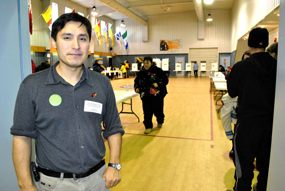Don’t forget to vote! Kirt Ejetsiak, the chief returning officer for the City of Iqaluit’s Dec. 13 by-elections, greets voters as they arrive at the entrance to Iqaluit’s cadet hall this morning. All eligible public government voters in Nunavut are today electing mayors, municipal councillors and district education authority members. At the same time, eligible Inuit beneficiaries are electing a president and two vice presidents to serve on the executive of Nunavut Tunngavik Inc. Voters in the eastern time zone still have about three hours to get to the polls, which close at 7:00 p.m. local time across Nunavut. (PHOTO BY JIM BELL)