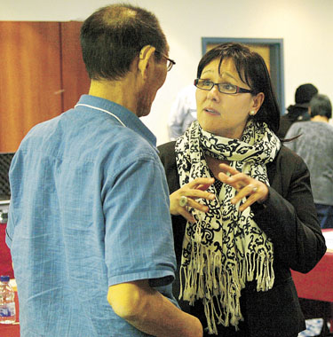 Nunavut MP Leona Aglukkaq speaks with Hall Beach Mayor Ammie Kipigak during a break in the Baffin mayors Forum in Iqaluit Feb. 15. Aglukkaq defended the new Nutrition North Canada program in the wake of an uproar over high grocery prices in Arctic Bay. (PHOTO BY CHRIS WINDEYER)