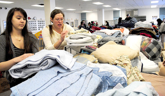 Students and staff at Inuksuk High School sort through piles of clothing and bedding donated March 24 to help victims of the devastating fire at building 4100 earlier that morning. Here's how Iqaluit residents can continue to help: DO NOT donate more clothes, kid's items, toothpaste, toothbrushes, soap or shampoo. DO donate kitchen items, small appliances, toiletries, clothes hangers, house cleaning items, new pillows, new bedding, toilet paper, paper towels and kleenex. No large items are being accepted. Residents may take donations to Inuksuk HIgh School or Nanook School in Apex. Any items not on the requested list will be turned away, but you are encouraged to give them to other charities or community groups. (PHOTO BY JIM BELL)