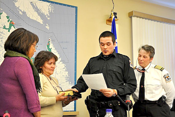 Paulusi Beaulne, 22, of Puvirnituq is sworn in as a member of the Kativik Regional Police Force Mar. 2, as KRPF police chief Aileen MacKinnon, to his right, and Kativik Regional Government chair Maggie Emudluk, far left, look on. Beaulne, who graduated from Quebec's police training program in Nicolet two years ago, said he wants to see more Nunavik youth join cadet programs in their communities. (PHOTO BY SARAH ROGERS)
