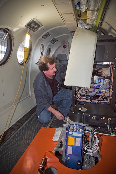 Crew chief Scott Sims installs instrumentation on NASA's B-200 airplane in preparation for the flight to Greenland to study polar ice. (PHOTO/ NASA/ SEAN SMITH)