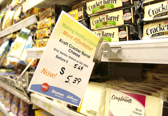 A sign in Iqaluit's Northmart store shows the new price of a block of cheese shortly after the April 1 launch of Nutrition North Canada. But opposition party candidates, and at least one Pond Inlet woman, say the program is worse than the food mail system it replaced. (PHOTO BY CHRIS WINDEYER)
