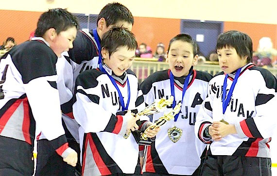 The Inukjuak Peewee tournament’s most valuable player and leading scorer Jaybeddi Amagoalik checks out his new trophies while his teammates Max Moorehouse, left and Josie Nastapoka, right, look on following the NYHDP PeeWee tournament held in Inukjuak April 17. (PHOTO/NYHDP)