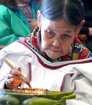 Elder Regeelie Paneak lights a qulliq during the official opening of the Piqqusilirivvik cultural school in Clyde River May 4. The school will open its doors to students in September. (PHOTO COURTESY OF CLEY)