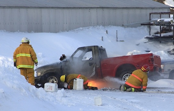 Before firefighters managed to put out this blaze, the entire front end of this Cambridge Bay truck was in flames, sending a plume of thick smoke into the air on May 15. The cause of the fire has not yet been determined. (PHOTO BY DERRICK ANDERSON/ RED SUN PRODUCTIONS)