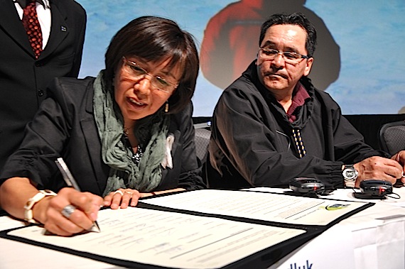 Maggie Emudluk, chair of the Kativik Regional Government, signs the Plan Nord on May 9 at the Lévis Congress Centre while Makivik Corp. president Pita Aatami watches. (PHOTO BY SARAH ROGERS)