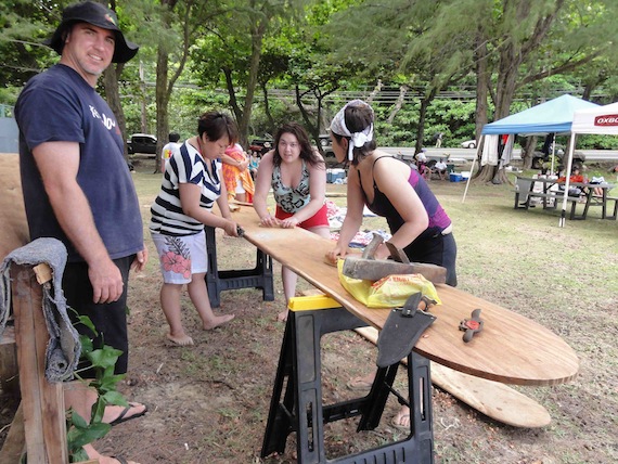 Lily Maniapik, Becky Okatsiak and Emila Ipkornerk get some lessons and practice at the art of traditional surf board making during Nunavut Sivuniksavut's trip to Hawaii.  The tradition of surfing among Native Hawaiians goes back hundreds of years. Only a select few people are still involved in making the traditional ones from wood. this was part of a day-long activity with Na Kama Kai, a non-profit organization set up to help young native Hawaiians learn more about their ocean traditions. (PHOTO BY M. HANSON)