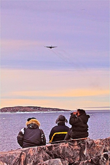 This photo was taken June 12 of beluga hunters from Kaniqsujuaq scanning the horizon for belugas in the Hudson Strait, as a Hercules passes by in its search for the three missing Salluit hunters. (PHOTO BY YAAKA JAAKA)
