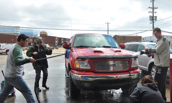 Volunteers scrub down cars and trucks at Iqaluit's firehall June 25 to raise money for the local Kids on the Beach daycare centre. (PHOTO BY SARAH
ROGERS)