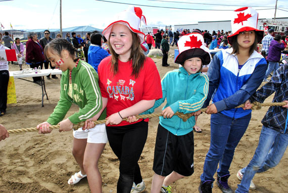 Iqaluit youngsters enjoy a tug-of-war early in the afternoon of July 1 in front of Nakasuk School, where Iqaluit residents gathered by the hundreds to enjoy Canada Day 2011. (PHOTO BY JIM BELL)