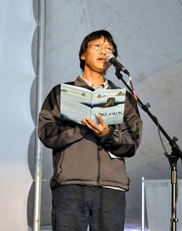  Iqaluit storyteller Elisha Kilabuk reads July 2 from his new children's book called The Qalupalik, a story about magical creatures who live under the sea ice. (PHOTO BY SARAH ROGERS)