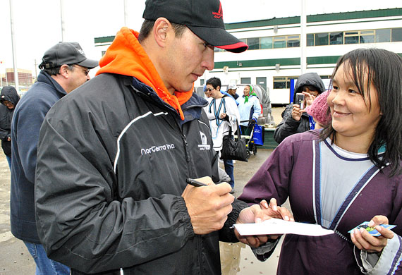 Hockey star Jordin Tootoo signs autographs at Nunavut Day celebrations in Iqaluit July 9.  Iqaluit residents listened to music and enjoyed barbecued and country food for most of the afternoon. (PHOTO BY JIM BELL)