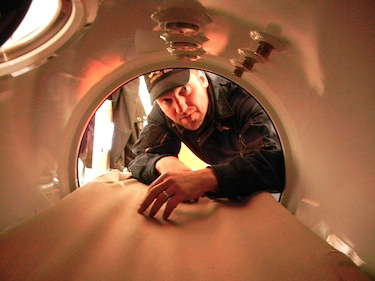 This is a place you hope you don't have to spend any time in. Leading Seaman Murray Rankin peers into the two-person decompression chamber on the Camp Nanook site in Resolute. If a diver develops the bends from coming to the surface too quickly, he or she will come into this tiny chamber, which looks somewhat like a pressure cooker, and go through a decompression process that can take up to five hours, accompanied by a second person who monitors the diver’s condition. (PHOTO BY JANE GEORGE)