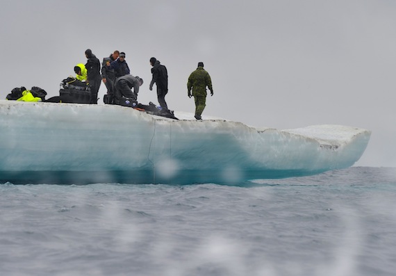 Canadian military divers and United States Coast Guard members wait on an iceberg in Resolute Bay, Nunavut, for the remainder of their team to arrive by a rigid hulled inflatable boat during Op Nanook. (PHOTO BY SGT. NORM MCLEAN/CANADIAN FORCES COMBAT CAMERA/DND)