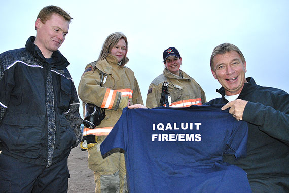 Iqaluit firefighters honour Rick Hansen, the Man in Motion, with a souvenir T-shirt Sept. 25, at a community event held at Nakasuk School. Hansen, a renowned paralympian and activist for the rights of the disabled, is visiting Iqaluit Sept. 25 and Sept. 26.