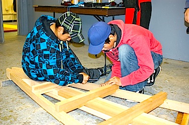 Irqu Uqaituk and Juanassie Eliyassialuk work on an umiak which they and their classmates at Iguarsivik school in Puvirnituq made for the film