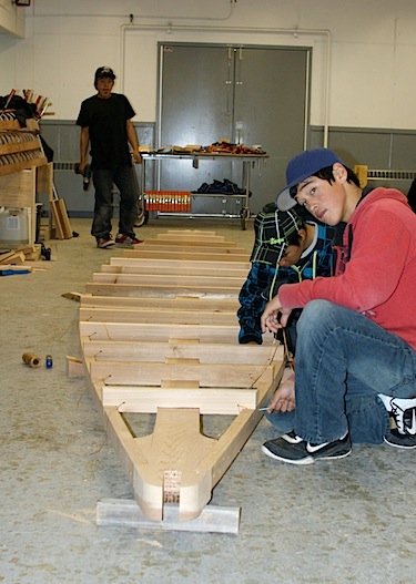 Noadamie Qumaluk, Irqu Uqaituk and Juanassie Eliyassialuk work on the umiak which they and their classmates at Puvirnituq's Iguarsivik School made for the film