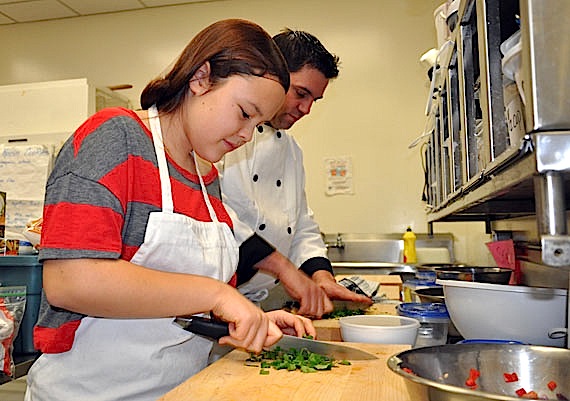 Inuksuk High School's Skills Nunavut brings new taste experiences to Rachel Niego-Akavak, left, who chops cilantro to add to her batch of homemade salsa, alongside her cooking instructor, Aaron Watson. (PHOTO BY SARAH ROGERS)