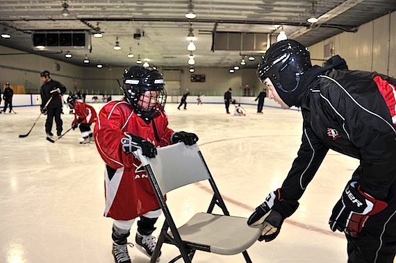Hockey Canada instructor Ludovic Lord, right, helps a young hockey player with his skating skills in Tasiujaq last weekend. (PHOTO COURTESY OF THE NYHDP)