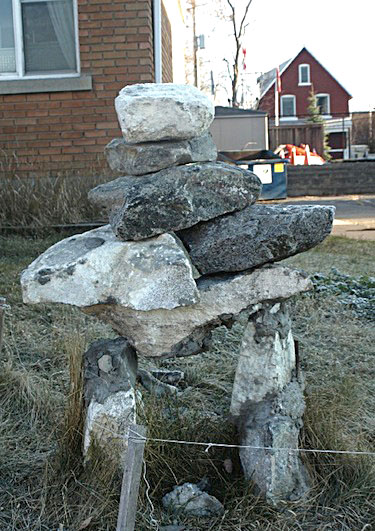 This photo from the 2009-10 annual general report of Tungasuvinngat Inuit shows an inuksuk standing in front of one of the buildings owned by the Ottawa-based community centre for Inuit.