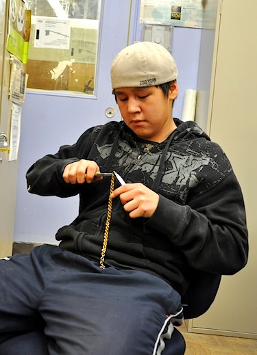 Damien Macpa, a jewellery/metalwork student at Inuksuk High School, works to connect the bronze links of a chain. (PHOTO BY SARAH ROGERS)