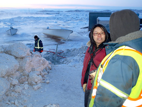 Iqaluit Mayor Madeleine Redfern speaks to a city employee on the morning of Jan. 13 near the Iqaluit breakwater, where workers have been coping with floods in the area caused by a broken water main at Inuksuk High School. The break, which occurred at around midnight, saw the city's reservoir drop by about 20 million litres in 20 minutes. As of the morning of Jan. 13, city officials are asking Iqaluit residents to conserve water until levels at the reservoir build up again. (PHOTO BY DEAN MORRISON)