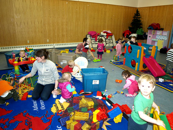 Iqaluit mom Sara Minogue is surrounded by children Jan. 27, at the Parents and Tots drop-in held three times a week at the Abe Okpik Community Centre in Apex. (PHOTO BY DEAN MORRISON)