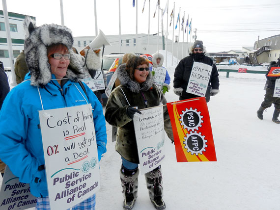 Unionized workers at the Government of Nunavut, represented by the Nunavut Employees Union and the Public Service Alliance of Canada, holding a noon-hour rally Feb. 20 behind the Nunavut legislature in Iqaluit. The GN is offering no wage increase in the first year of a new contract, and one per cent increases in each of the next three years. The union seeks 5 per cent wage increases in each of three years, and changes to a long list of non-monetary items in its collective agreement with the GN, which expired in September 2010. The two sides spent all weekend at talks inside the Nova Inn with mediator Vince Ready, but have been unable to break the impasse. (PHOTO BY JIM BELL)
