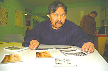 The late Adamie Nutaraluk, while serving out a sentence at the Baffin Correctional Centre in 2007, looks at photographs from the Hamilton Mountain tuberculosis sanatorium, where he stayed for several years as a child. An inquest that started March 12 in Iqaluit is looking at his Dec. 9, 2009 death inside an RCMP jail cell in Iqaluit. (FILE PHOTO)