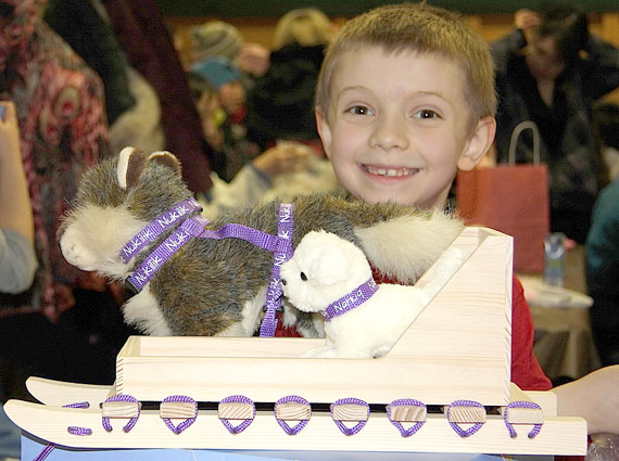 Cameron Gillard of Cambridge Bay grins after winning this toy komatik and sled dogs in a silent auction held March 31 at the Luke Novoligak Hall in Cambridge Bay. Money raised by the silent auction and auction at the event — more than $5,500 — will go towards the 