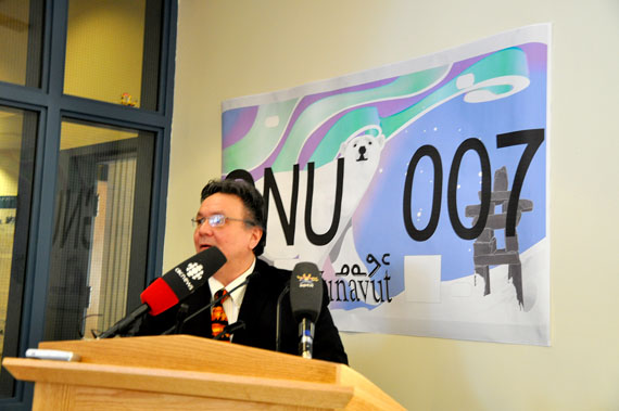 Economic Development and Transport Minister Peter Taptuna unveils Nunavut's new license plate design at the territorial legislature March 6. The new plate features a night scene with northern lights, a polar bear and an inuksuit, to