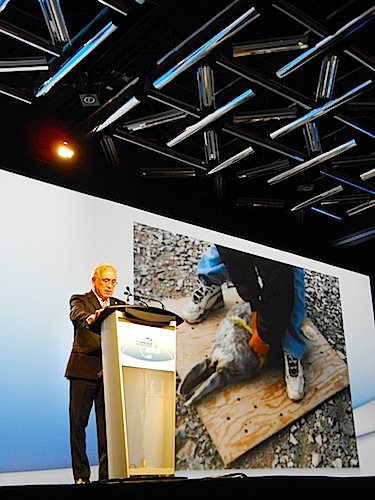 Aqqaluk Lynge, who heads the Inuit Circumpolar Council, speaks April 24 at the International Polar Year science conference in Montreal as photos from the Arctic are screened on a backdrop. (PHOTO BY JANE GEORGE)