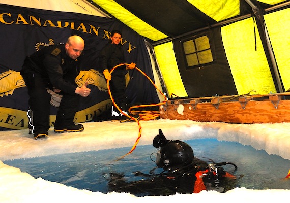 Divers surface through the ice during Nunalivut 2012, the Canadian military’s annual spring sovereignty operation now underway in the High Arctic. A dive team on Devon Island is conducting diving operations as part of Defence Research and Development Canada’s $10-million northern watch project.That project installs undersea surveillance devices in various locations along the Northwest Passage. Nunalivut, which started April 10, wraps up May 1. (PHOTO COURTESY OF COMBAT CAMERA/ DND)
