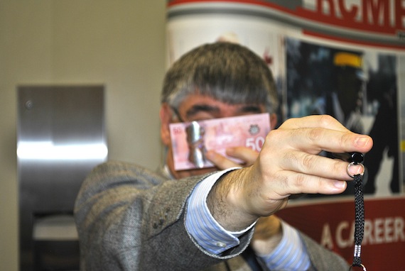 Marc Trudel, an analyst with the Bank of Canada, demonstrates how you can check to see if you have a fake $50 bill — the new plastic bills have a rainbow-coloured number 50 inside their semi-transparent frosted maple leaf. When you put a light through the leaf, you can see the number pop out.  (PHOTO BY JANE GEORGE)