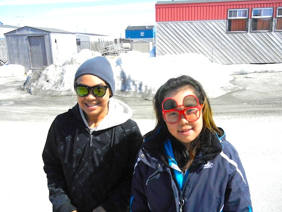 A sunny, warm day in Puvirnituq: Andrew Sivuarapik, 14, and Maina Ittukalak, 13, both wear new sunglasses bought in Montreal as they walk around town. (PHOTO BY JANE GEORGE)