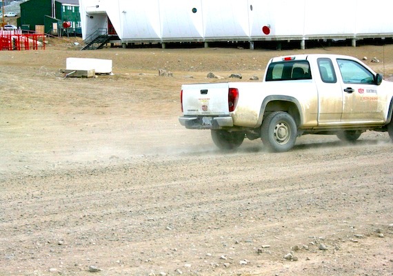 Plumes of dust, like this one spewing behind this dust-crusted pickup truck in Iqaluit, are common sights along the unpaved roads in Nunavut communities. (PHOTO BY DAVID MURPHY)