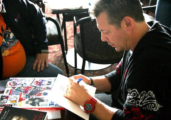 Theo Fleury, former professional hockey player for the Calgary Flames, Colorado Avalanche, New York Rangers, and Chicago Blackhawks, Tappara of Finland's SM-liiga, and the Belfast Giants, Fleury signs an autograph in his own book for a fan in Iqaluit at the Frobisher Inn May 22. The book, titled 
