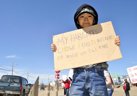 Eight-year-old Kyle Mablick holds a sign in a food price protest that started around 1:00 p.m. June 21 in Iqaluit across the road from the Northmart store. (PHOTO BY JIM BELL)