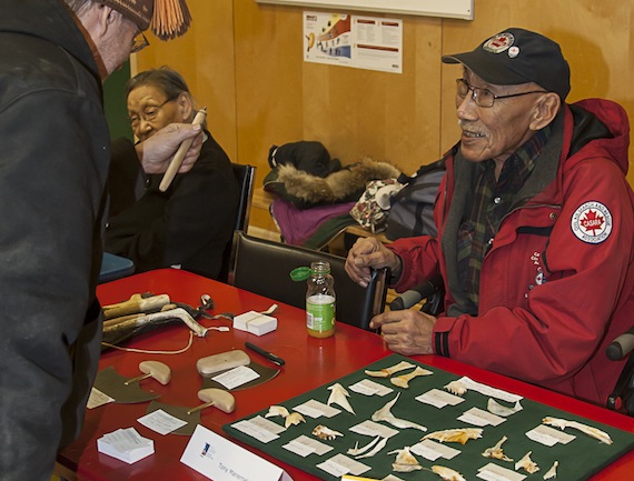 Tony Maneraluk discusses his hand-crafted jewelry and ulus with a customer Nov. 20 at the Kivalliq Trade Show's art market at Leo Ussak School in Rankin Inlet. The trade show, which got off to a late start due to stormy weather conditions, provides a forum for business, industry, government, Inuit organizations and exploration and mining companies. It includes the art market, a one-day trade show as well as presentations for the business and local community. The trade show floor will be open to the public at Maani Ulujuk School Nov. 21 from 10 a.m. to noon and from 1:30 p.m. to 4 p.m. (PHOTO BY DOUG MCLARTY)
