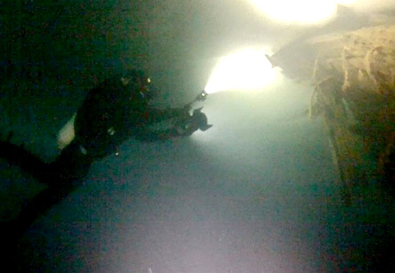 Swimming under the ice, a diver from Norway approaches the sunken hulk of the Maud for a better view of the ship once sailed by Norwegian explorer Roald Amundsen.